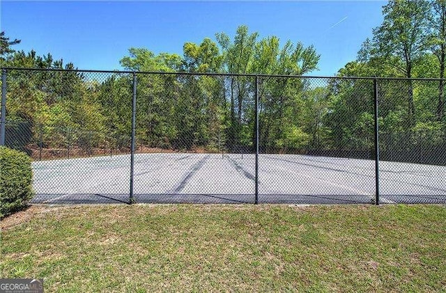 view of sport court with a yard