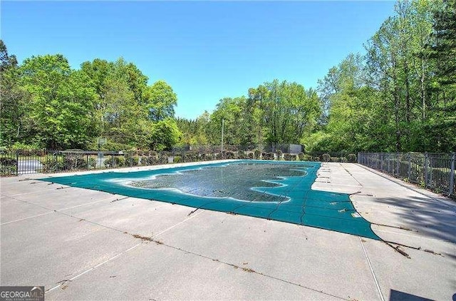 view of pool with a patio area, a fenced in pool, and fence