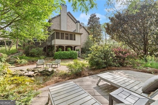 3749 Watkins Pl NE, Brookhaven, GA 30319 - rear view of house with stairway, a patio, a sunroom, and a chimney