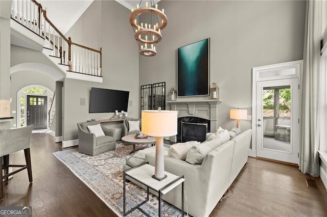 3749 Watkins Pl NE, Brookhaven, GA 30319 - living area featuring a towering ceiling, a chandelier, healthy amount of natural light, wood finished floors, and a fireplace