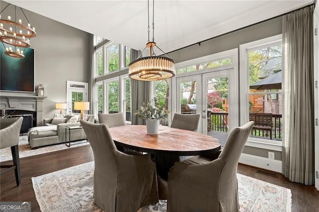 3749 Watkins Pl NE, Brookhaven, GA 30319 - dining space with a chandelier, french doors, a fireplace, and dark wood-style flooring