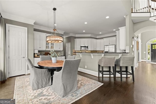 3749 Watkins Pl NE, Brookhaven, GA 30319 - dining room with crown molding, recessed lighting, a chandelier, baseboards, and arched walkways