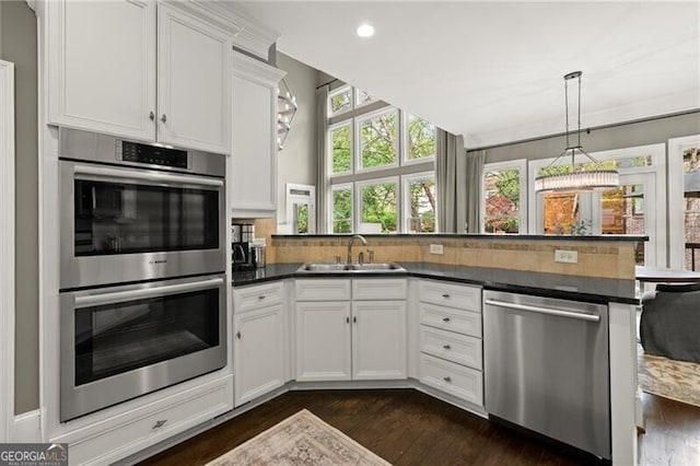 3749 Watkins Pl NE, Brookhaven, GA 30319 - kitchen featuring appliances with stainless steel finishes, a sink, a peninsula, dark wood finished floors, and white cabinetry