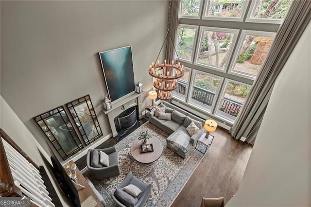 3749 Watkins Pl NE, Brookhaven, GA 30319 - living room featuring a towering ceiling, wood finished floors, a chandelier, and a high end fireplace