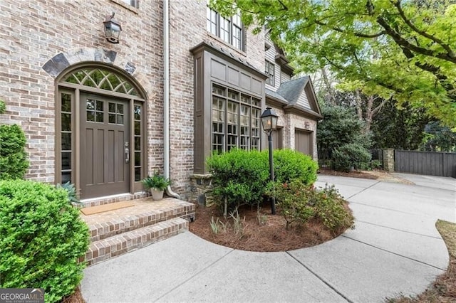 3749 Watkins Pl NE, Brookhaven, GA 30319 - view of exterior entry featuring brick siding, driveway, and a garage