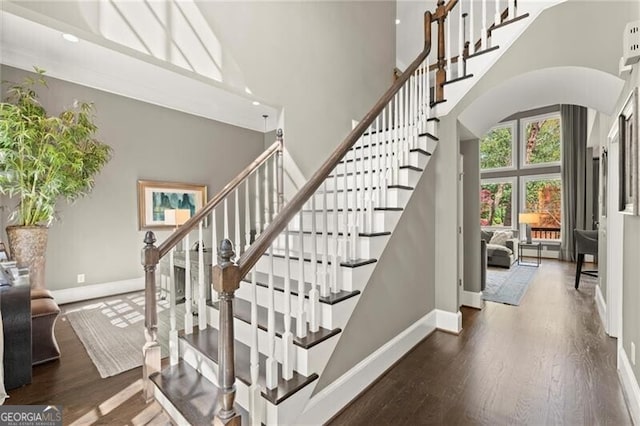 3749 Watkins Pl NE, Brookhaven, GA 30319 - stairway with a towering ceiling, baseboards, arched walkways, and wood finished floors