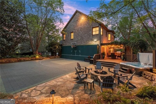 3749 Watkins Pl NE, Brookhaven, GA 30319 - back of house at dusk featuring a fire pit, a deck, a hot tub, and a patio area