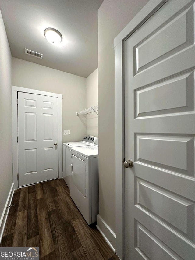 washroom with baseboards, dark wood-style floors, visible vents, washer and clothes dryer, and laundry area