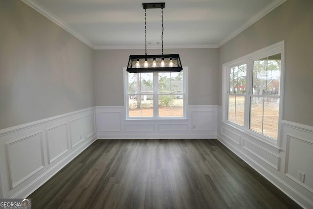 unfurnished dining area featuring dark wood-type flooring, crown molding, a decorative wall, and a wainscoted wall