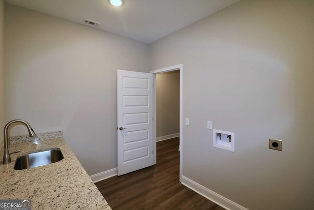 laundry area with laundry area, hookup for a washing machine, hookup for an electric dryer, a sink, and baseboards