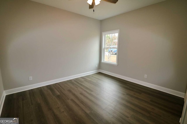 spare room with dark wood-style floors, baseboards, and a ceiling fan