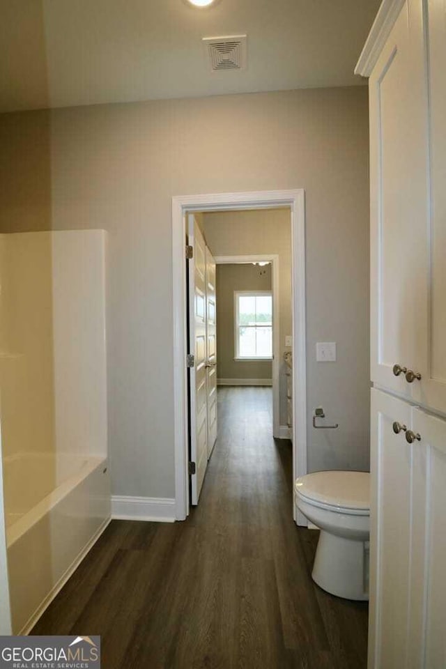 bathroom with visible vents, baseboards, toilet, and wood finished floors