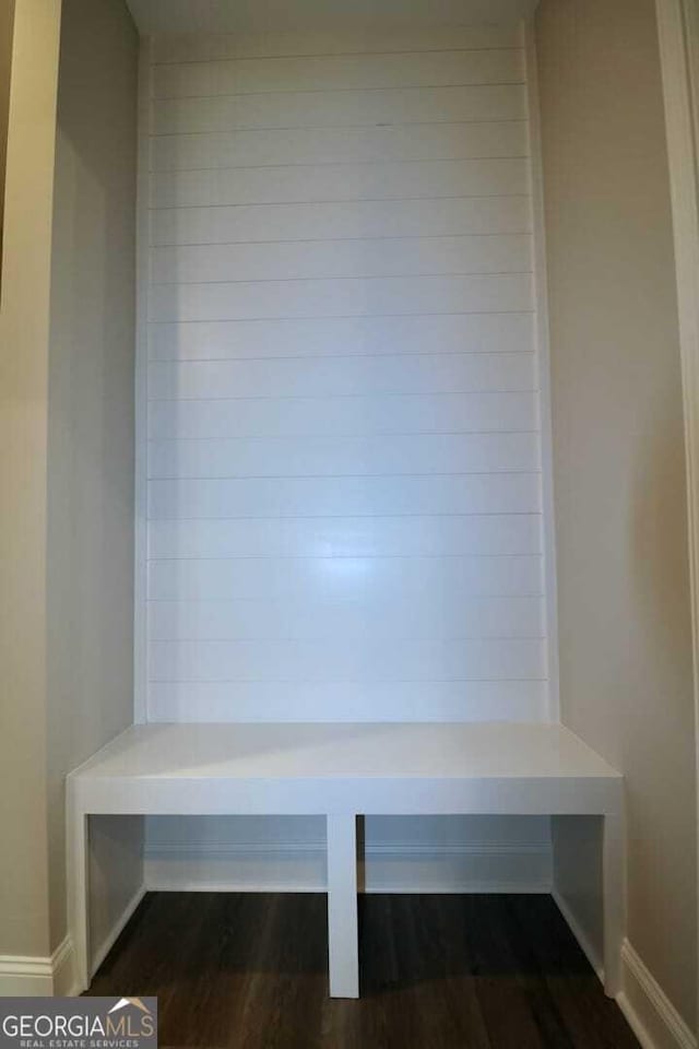 mudroom with dark wood-style flooring and baseboards