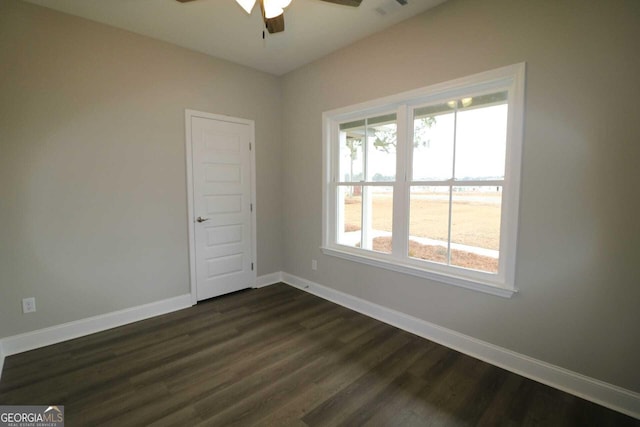empty room with dark wood finished floors, baseboards, and ceiling fan