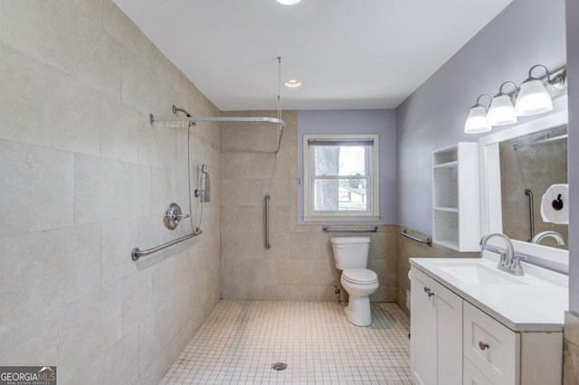 full bathroom featuring tiled shower, toilet, tile patterned flooring, and vanity