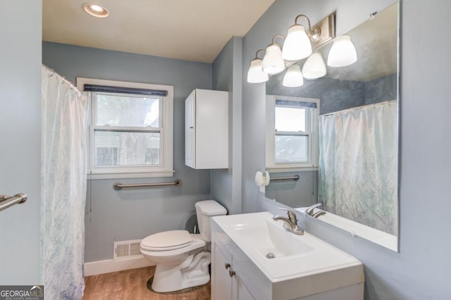 full bath with wood finished floors, toilet, vanity, baseboards, and visible vents