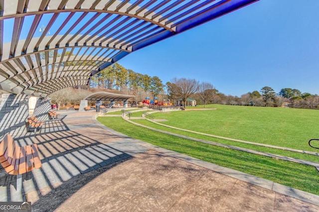 view of property's community with a lawn and a pergola
