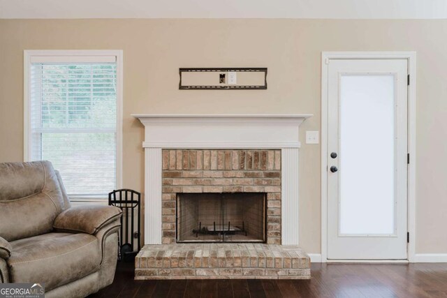204 Arapahoe Ct, Villa Rica, GA 30180 - living room with wood finished floors, a brick fireplace, and baseboards