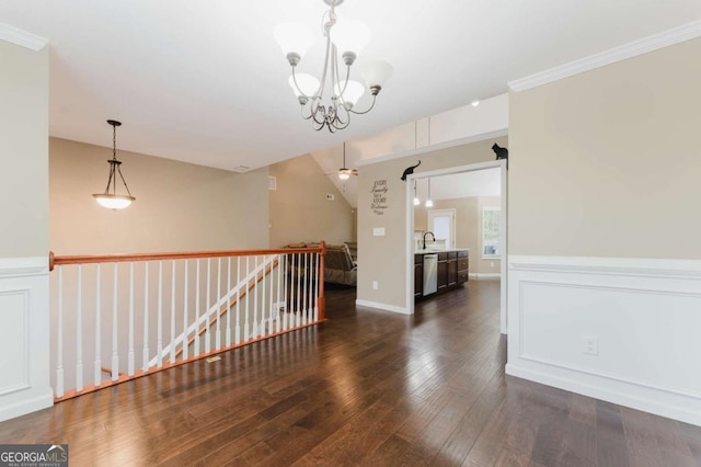 204 Arapahoe Ct, Villa Rica, GA 30180 - empty room with dark wood-type flooring, crown molding, a sink, and an inviting chandelier