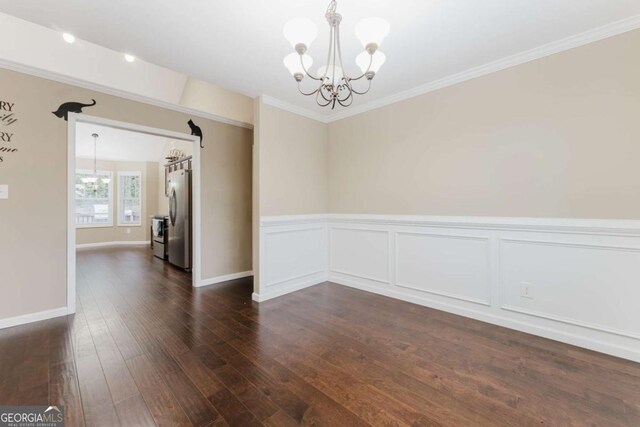 204 Arapahoe Ct, Villa Rica, GA 30180 - unfurnished room with a wainscoted wall, dark wood-style floors, an inviting chandelier, and crown molding