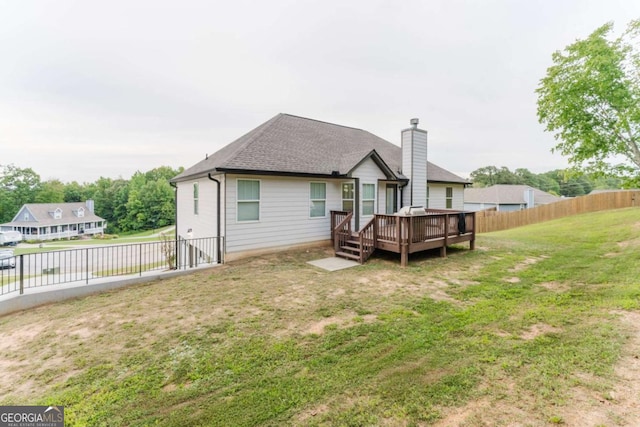 204 Arapahoe Ct, Villa Rica, GA 30180 - back of house with roof with shingles, a fenced backyard, a chimney, a wooden deck, and a lawn