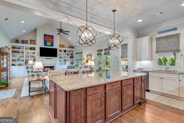 2616 Bent Pine Dr, Statham, GA 30666 - kitchen with dishwasher, a lit fireplace, a ceiling fan, wood finished floors, and white cabinetry