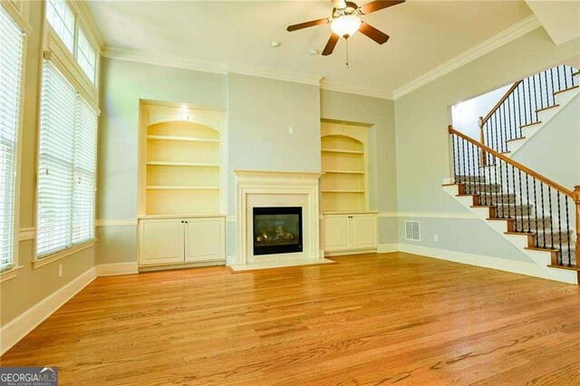 974 Regal Hills Ln, Mableton, GA 30126 - unfurnished living room featuring stairway, built in shelves, light wood-style floors, and baseboards