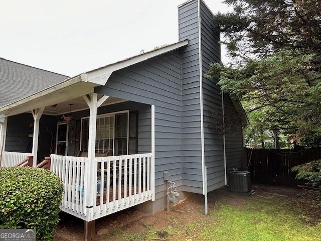525 Brooksdale Dr, Woodstock, GA 30189 - view of home's exterior featuring central AC unit, a porch, fence, and a chimney