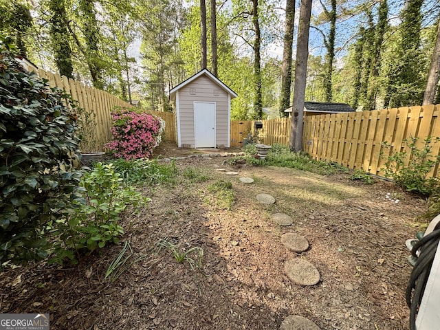 view of yard with a fenced backyard, an outbuilding, and a shed