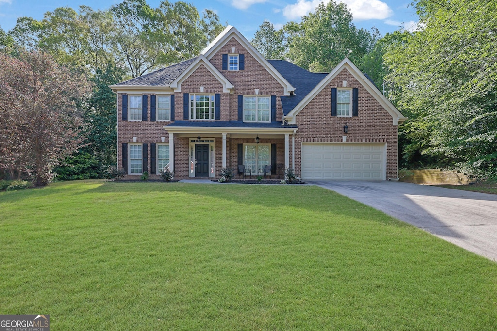 1877 Rocky Water Ct, Buford, GA 30519 - colonial-style house with concrete driveway, an attached garage, brick siding, and a front lawn