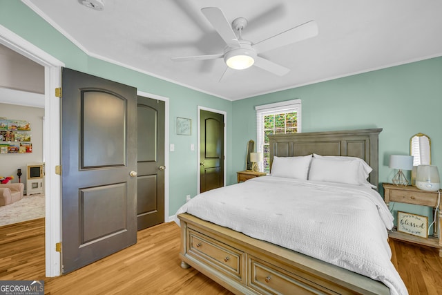 bedroom with ornamental molding, ceiling fan, light wood-type flooring, and baseboards