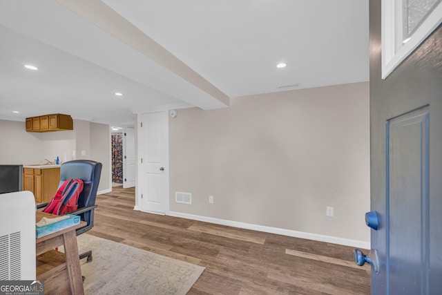 home office with light wood-style floors, visible vents, recessed lighting, a sink, and baseboards