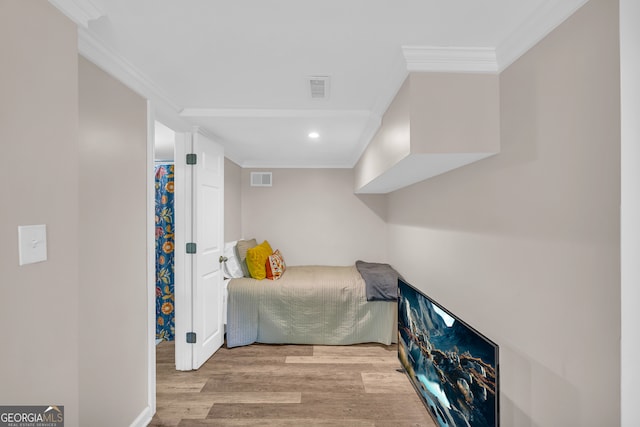 bedroom with recessed lighting, visible vents, crown molding, and wood finished floors