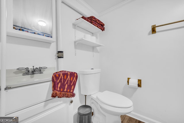 bathroom with baseboards, ornamental molding, toilet, vanity, and wood finished floors