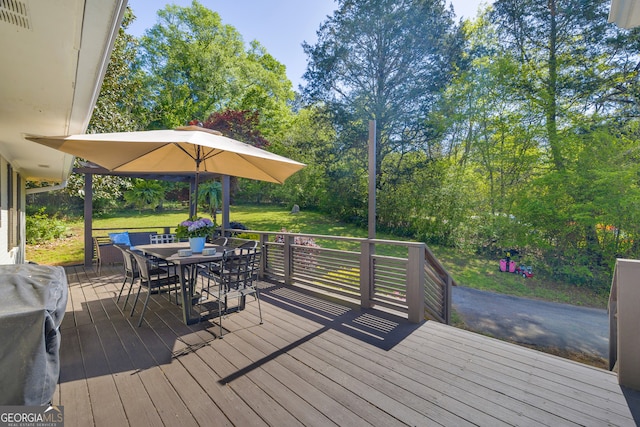 wooden deck with visible vents, outdoor dining space, a grill, and a lawn