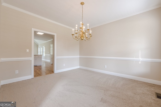 empty room featuring carpet, a notable chandelier, baseboards, and crown molding