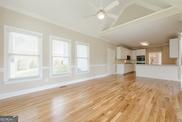 unfurnished living room featuring a wealth of natural light, visible vents, and ceiling fan