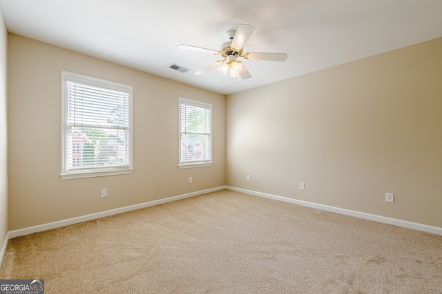 unfurnished room with visible vents, baseboards, ceiling fan, and carpet floors