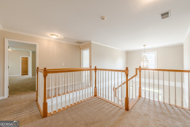 corridor with ornamental molding, visible vents, an upstairs landing, and carpet
