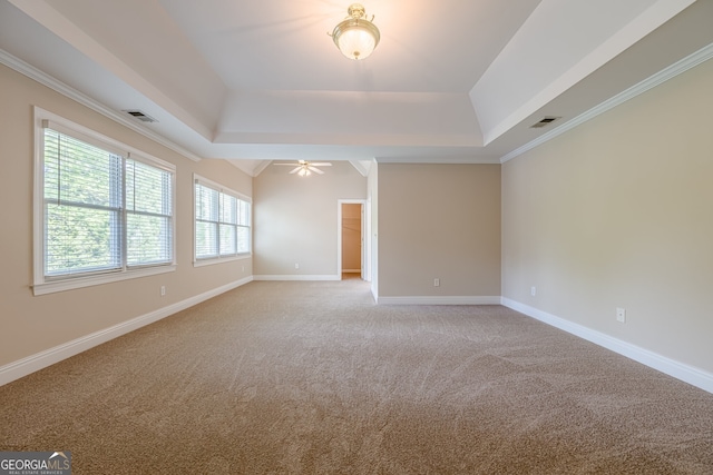 unfurnished room featuring light carpet, crown molding, visible vents, a tray ceiling, and ceiling fan