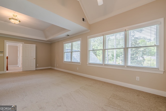 spare room featuring light colored carpet, ornamental molding, vaulted ceiling, visible vents, and baseboards