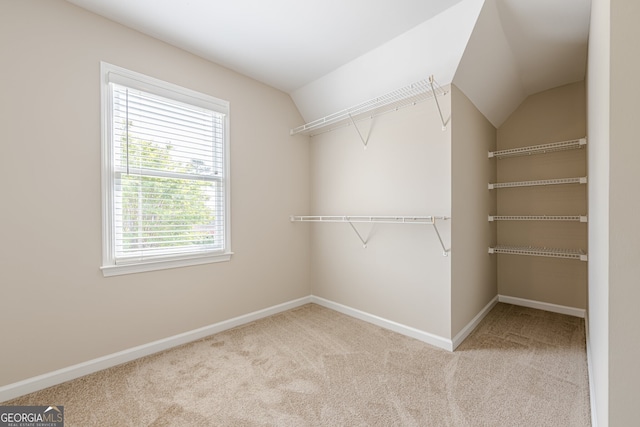 walk in closet with carpet and vaulted ceiling