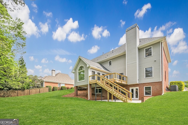 back of house featuring central AC, a wooden deck, a lawn, and a chimney