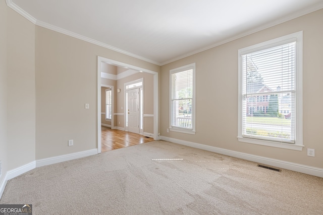unfurnished room featuring ornamental molding, visible vents, baseboards, and carpet flooring