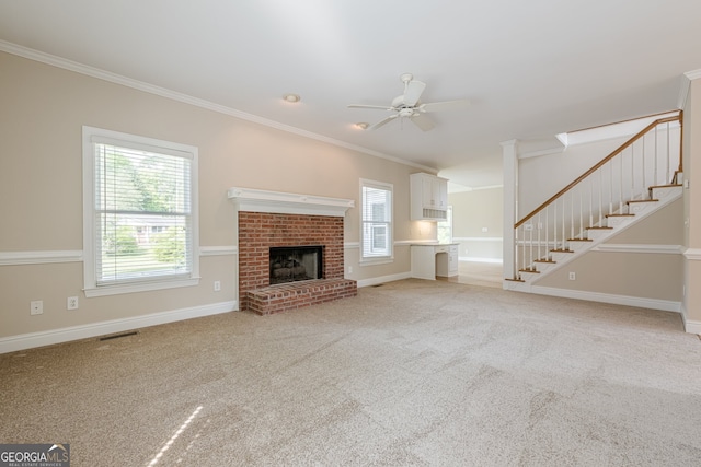unfurnished living room with ornamental molding, light carpet, stairway, a ceiling fan, and visible vents