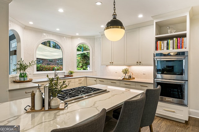kitchen featuring recessed lighting, a sink, light stone countertops, and stainless steel appliances