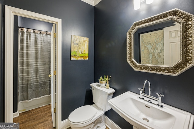 full bathroom with baseboards, a sink, toilet, and wood finished floors