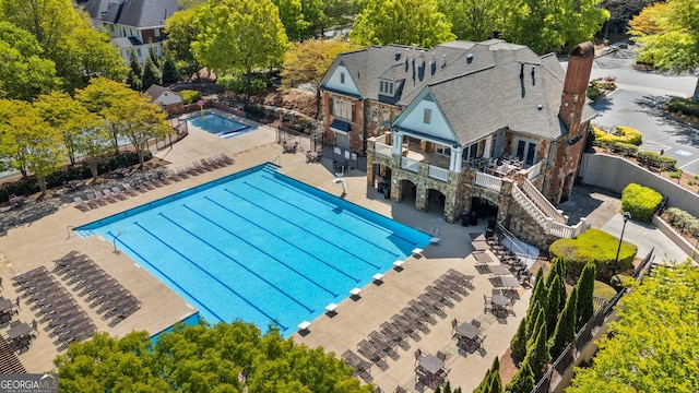 pool featuring fence, a patio, and stairs