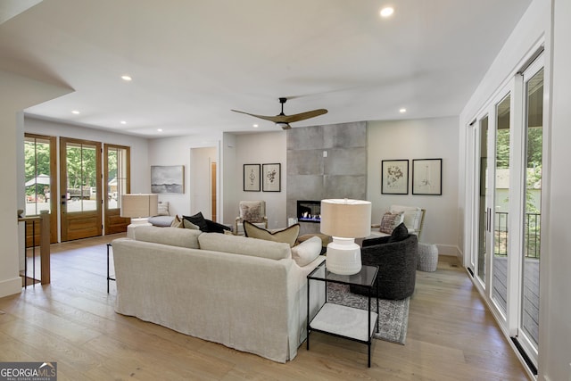 5535 Chestatee Landing Way, Gainesville, GA 30506 - living room featuring a tiled fireplace, light wood-type flooring, ceiling fan, recessed lighting, and baseboards