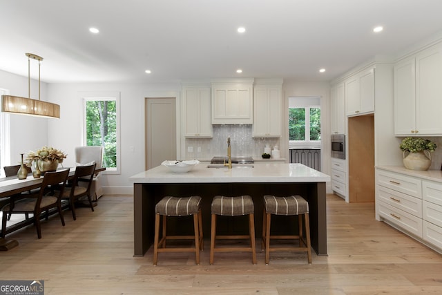 5535 Chestatee Landing Way, Gainesville, GA 30506 - kitchen featuring decorative backsplash, plenty of natural light, a breakfast bar area, light wood-style flooring, and recessed lighting